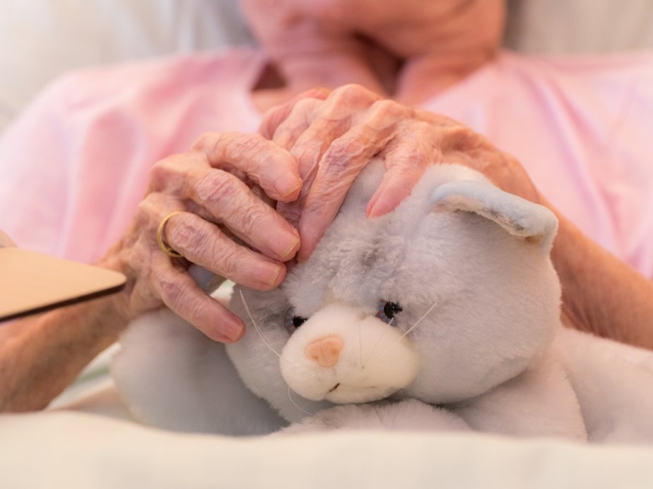 Eine Bewohnerin hält ein Stofftier.