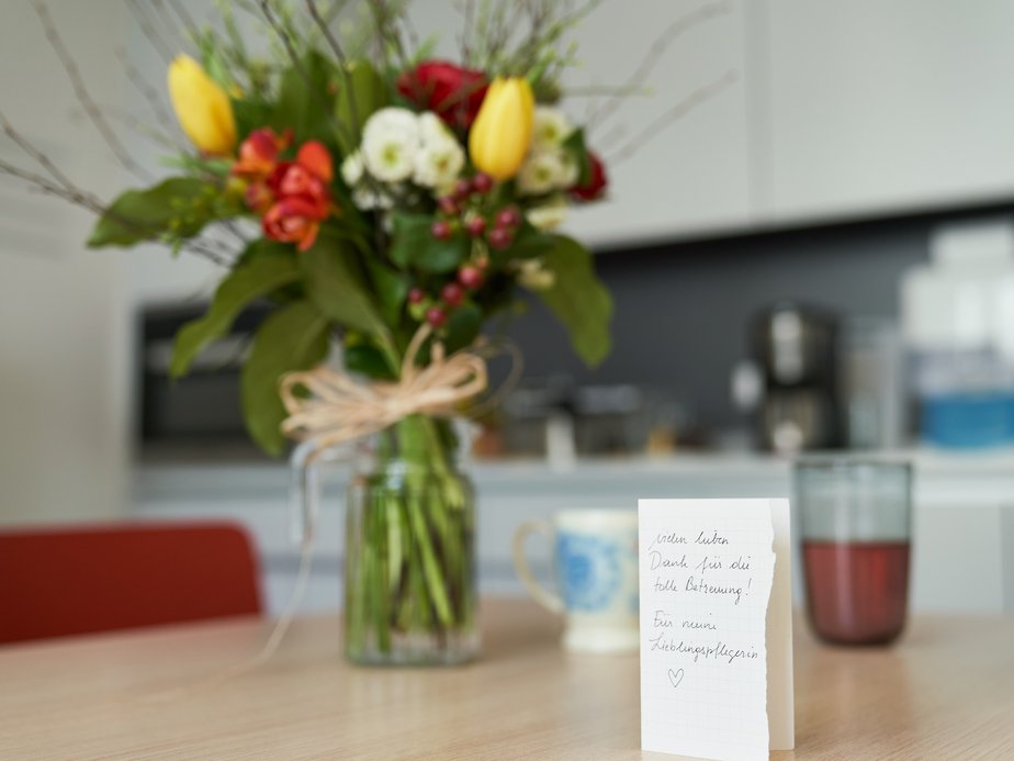 Eine Karte und ein Blumenstrauß stehen auf einem Tisch.